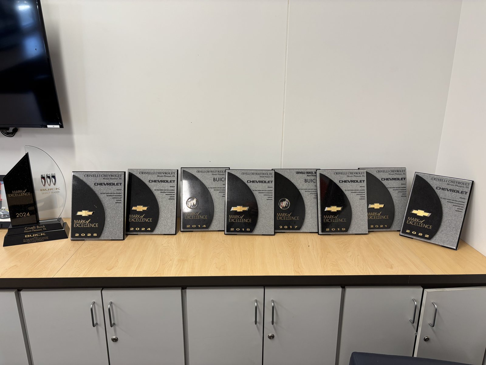 Row of Chevrolet GM Mark of Excellence award trophies won by Crivelli Chevrolet Buick in Mount Pleasant, PA